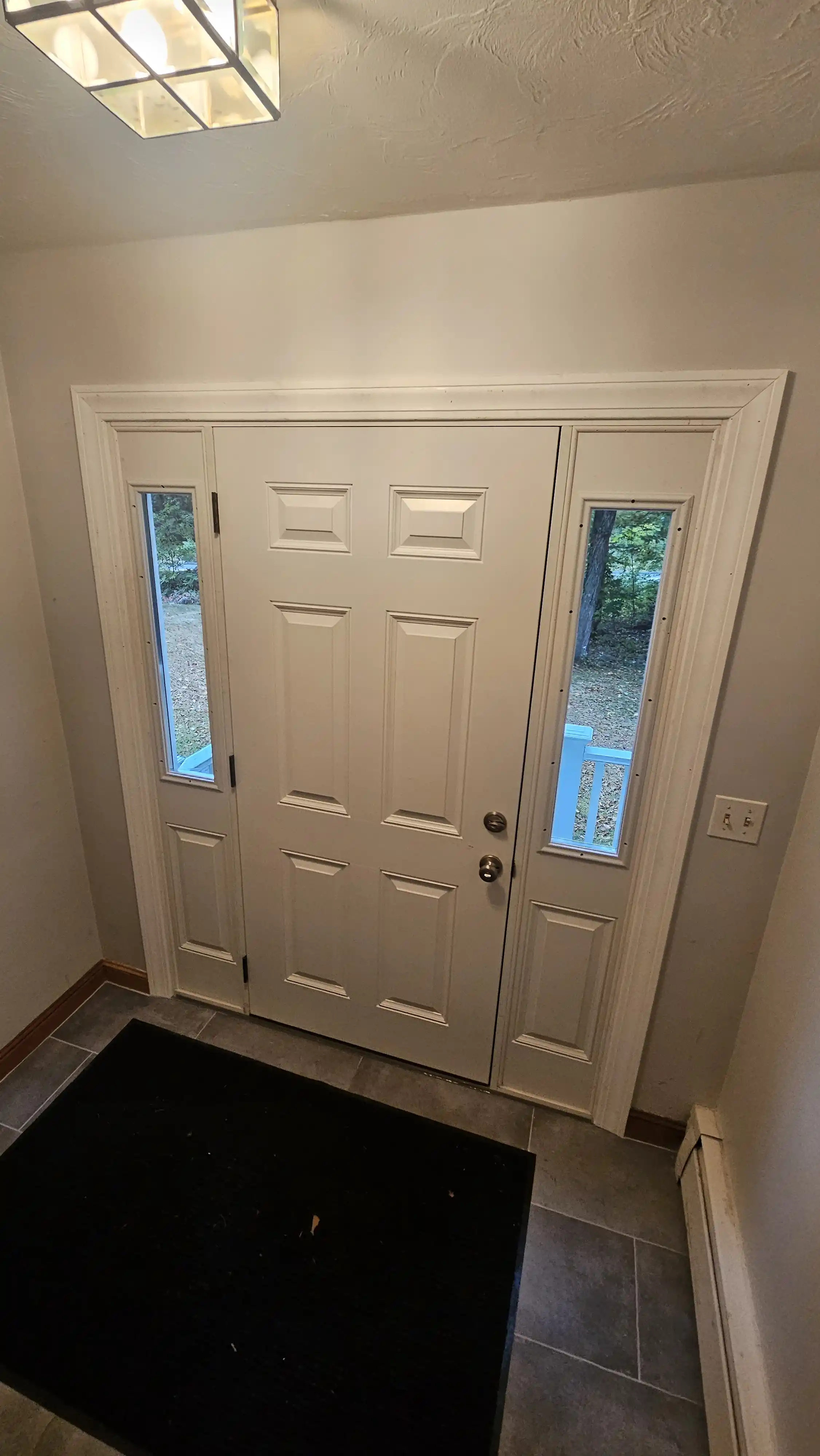 Classic white entrance door with rectangular panels and two sidelites