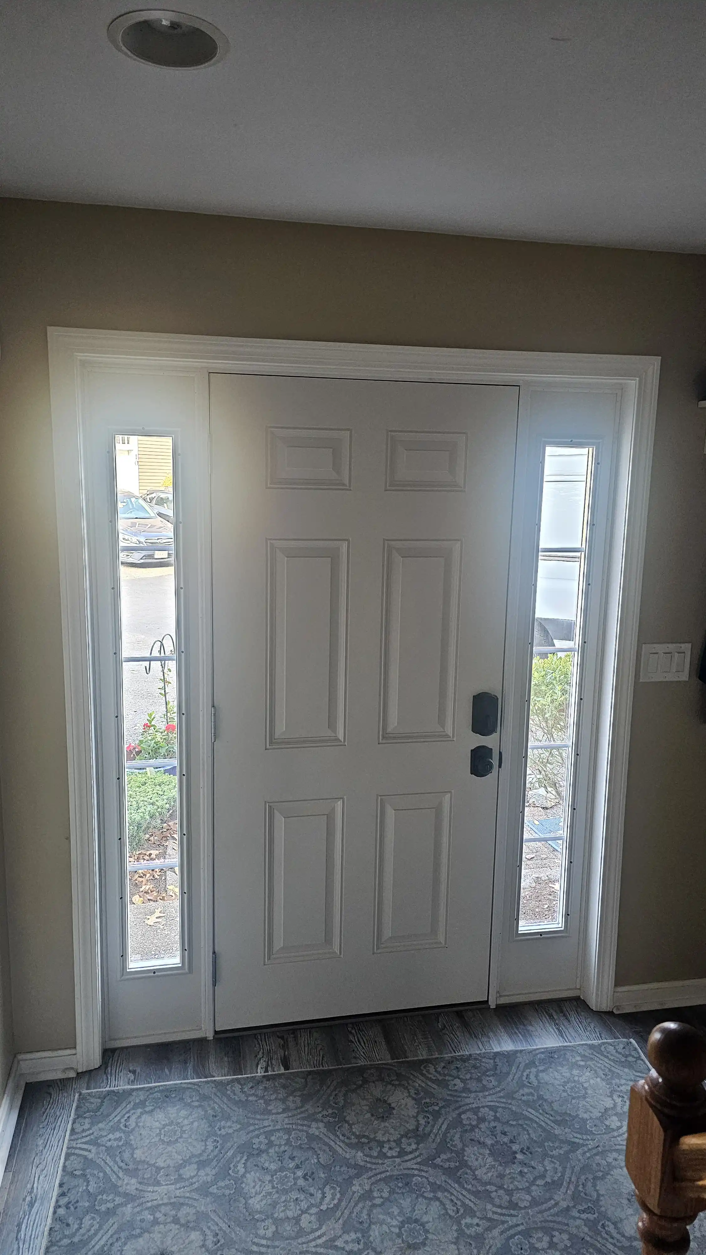 White entrance door with large glass sidelites and a black handle