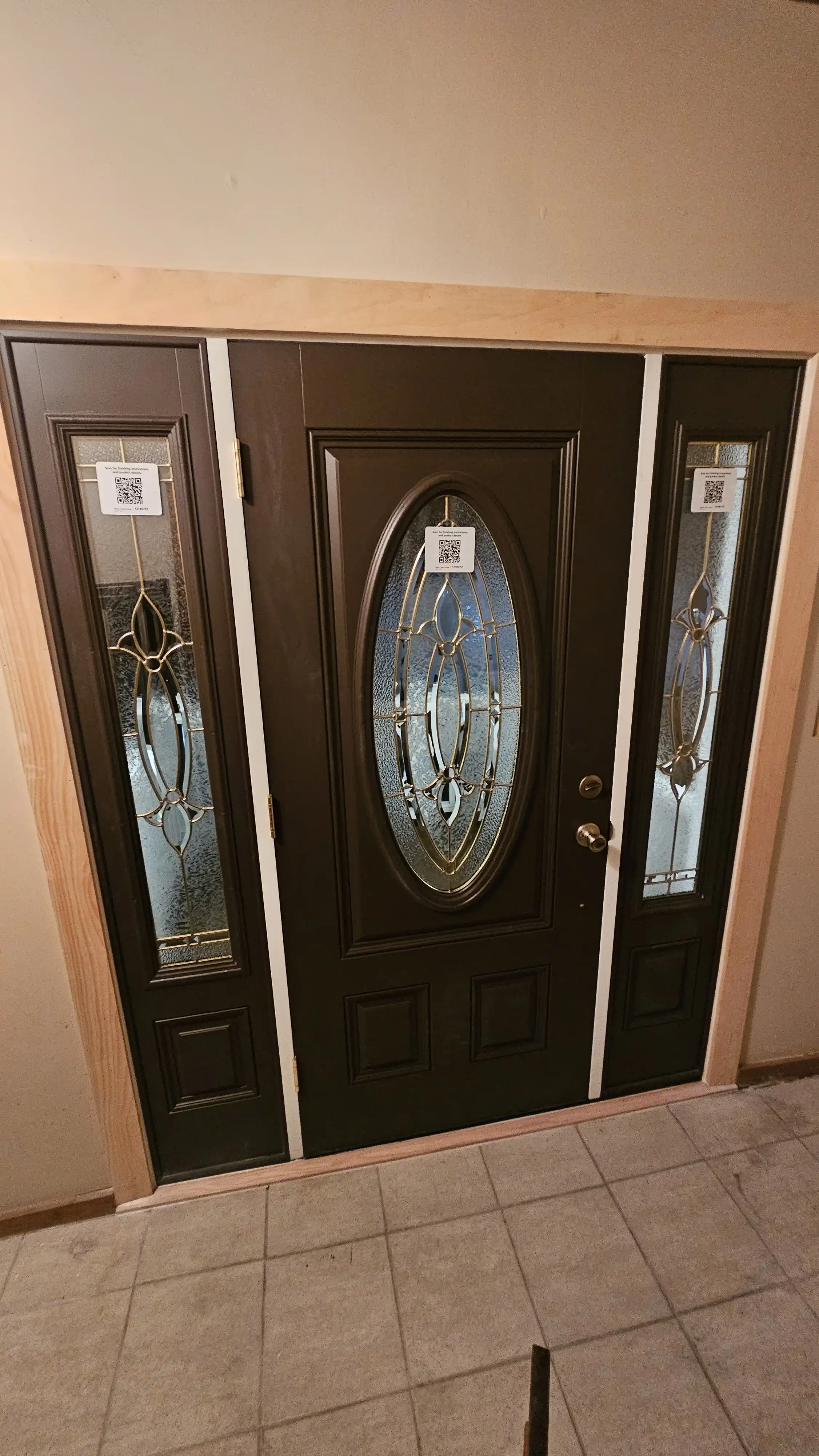 Interior view of a dark wooden door with oval glass and two sidelites