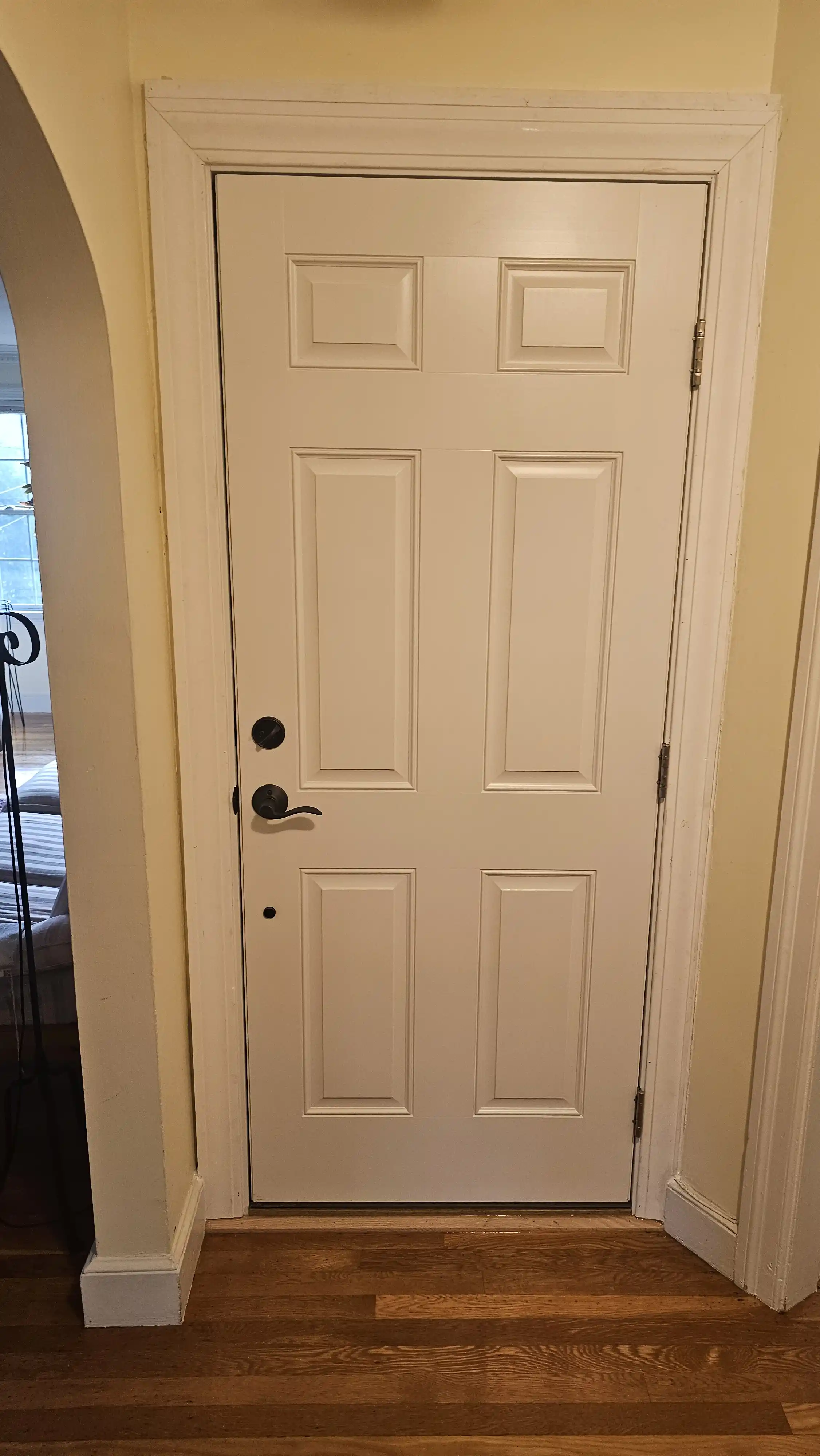 White entry door with six recessed panels and silver hardware