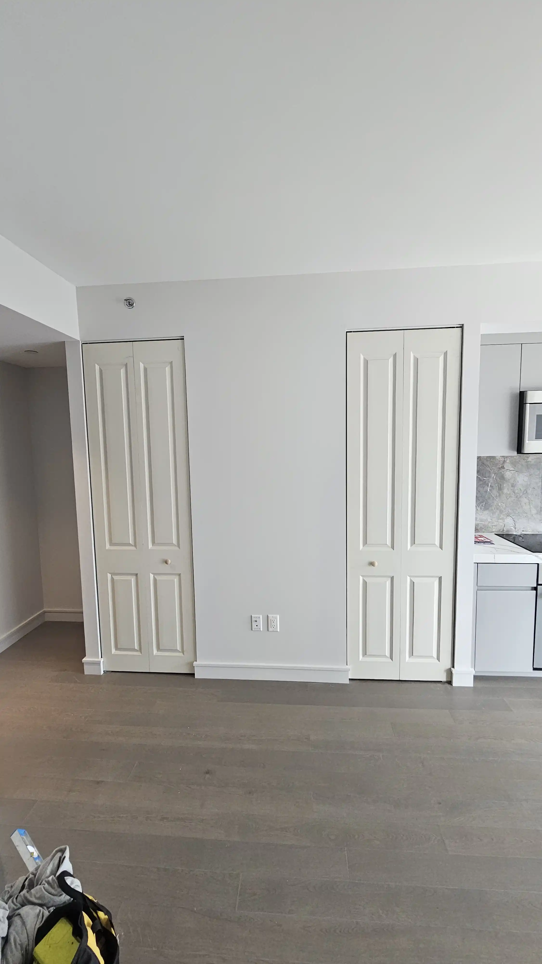 White bi-fold doors with four vertical panels, simple round knobs in the center
