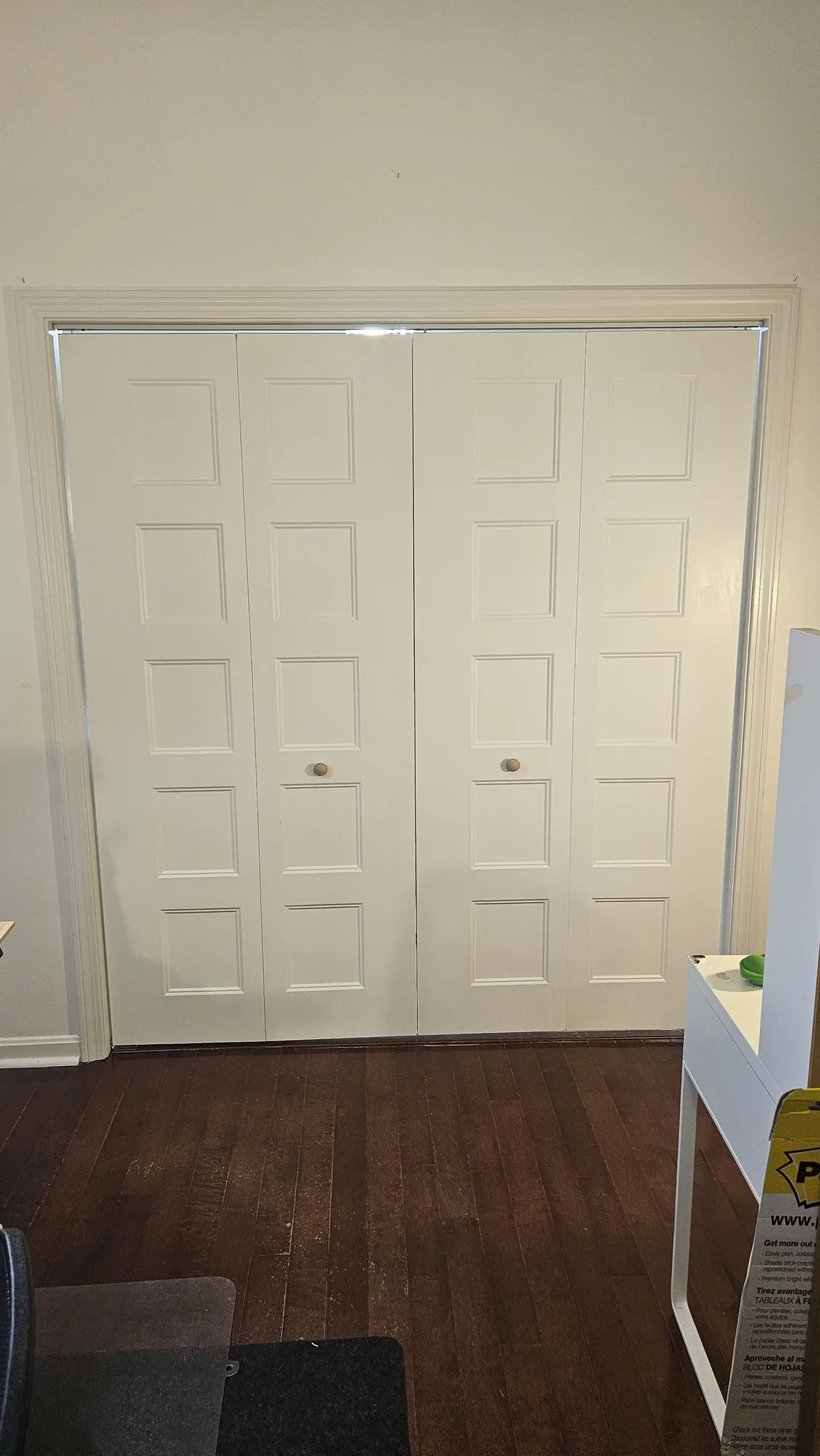 Traditional white bi-fold doors with arch-top paneling, small wooden knobs