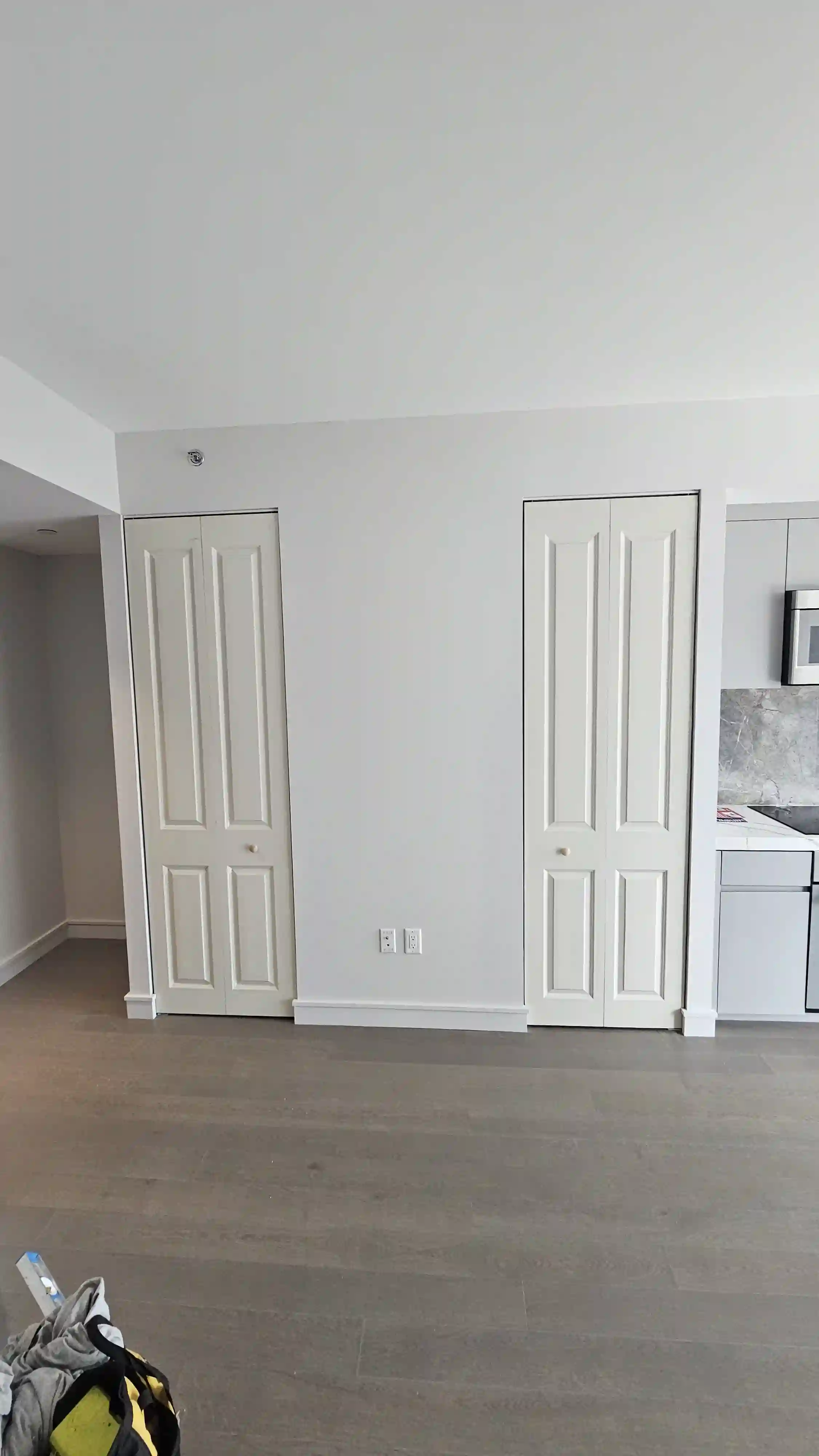 White bi-fold doors with four vertical panels, simple round knobs in the center