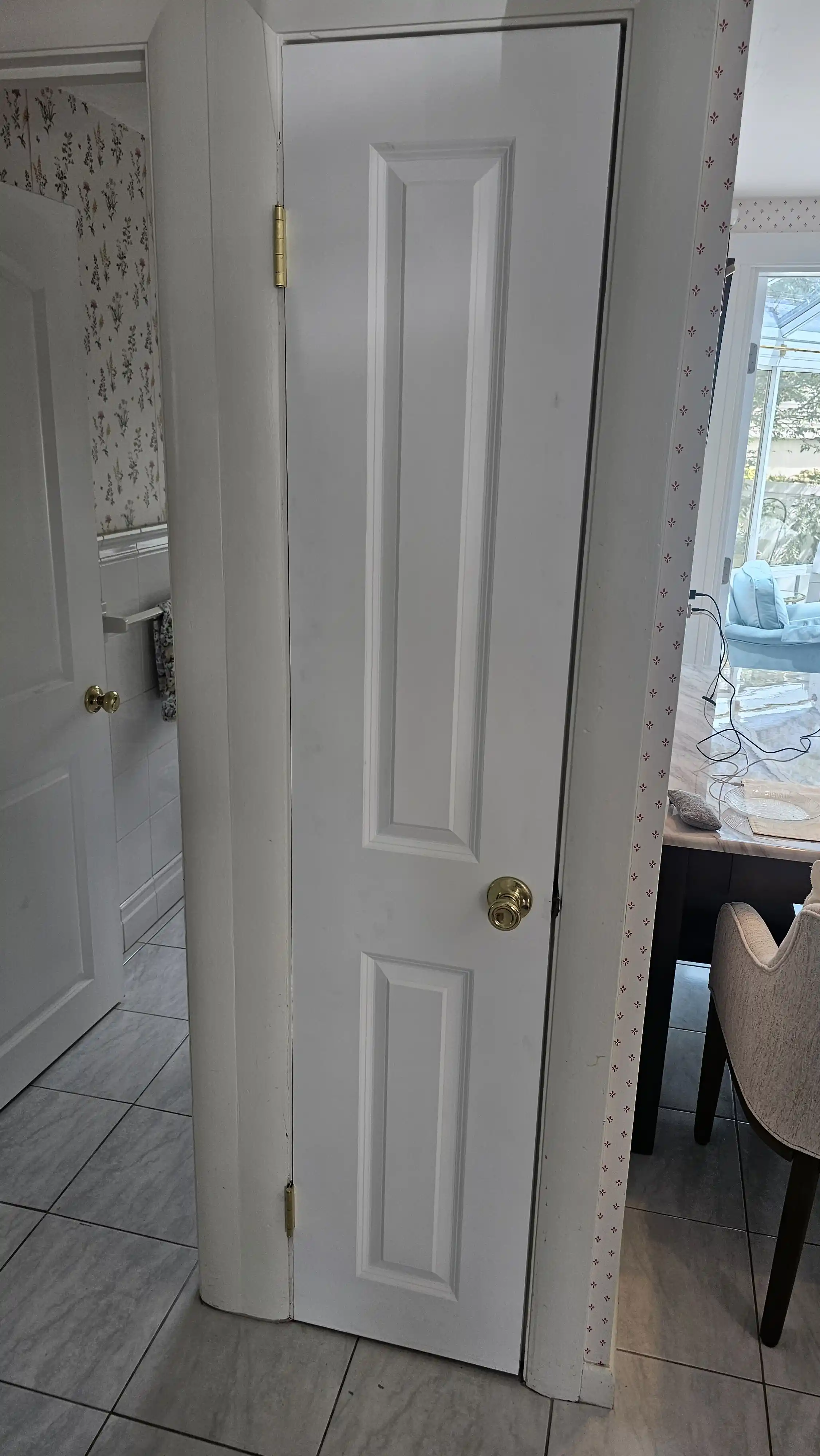 White interior door with a curved panel design and brass doorknob