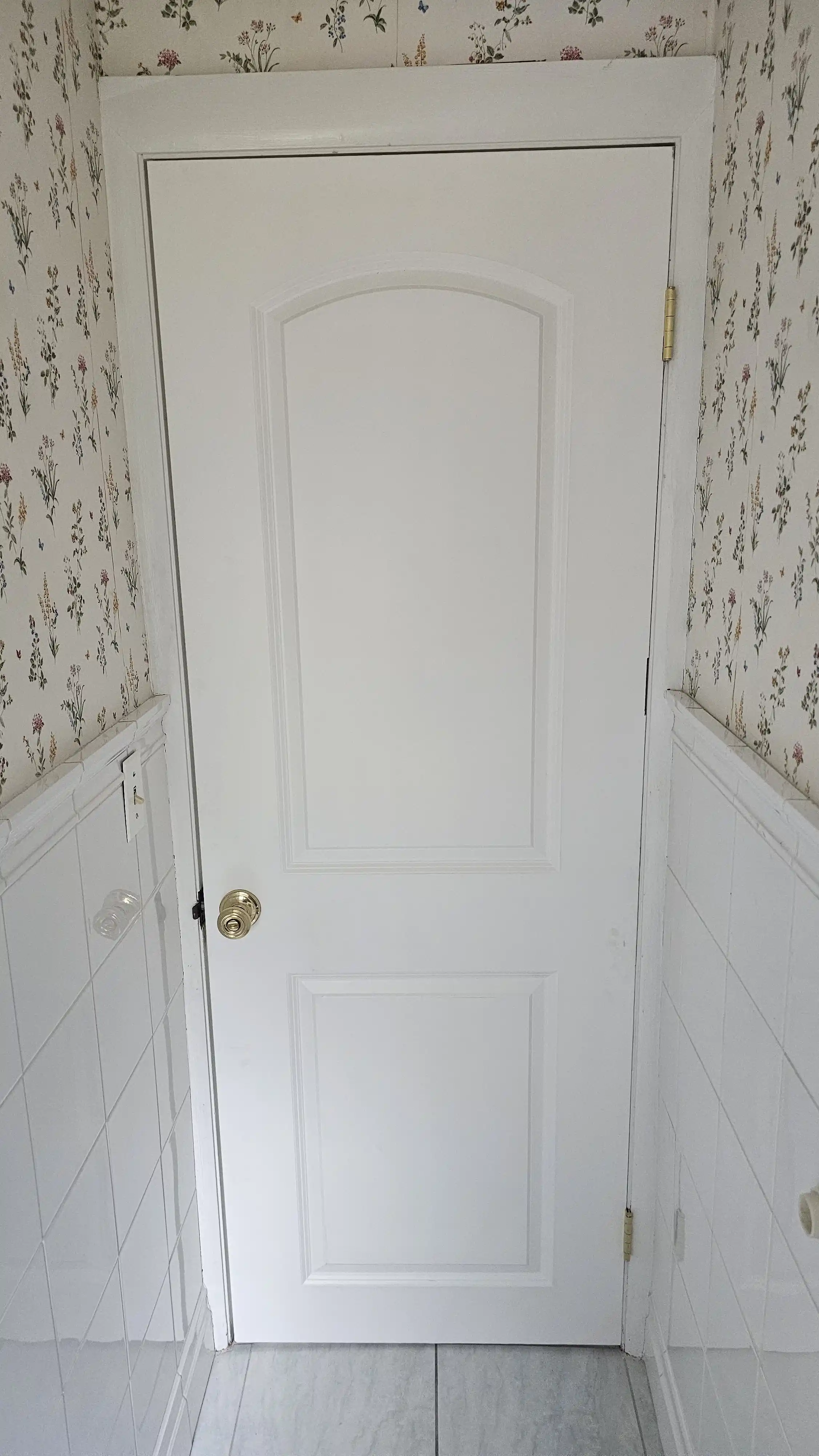 Classic white six-panel door with wood trim and silver doorknob