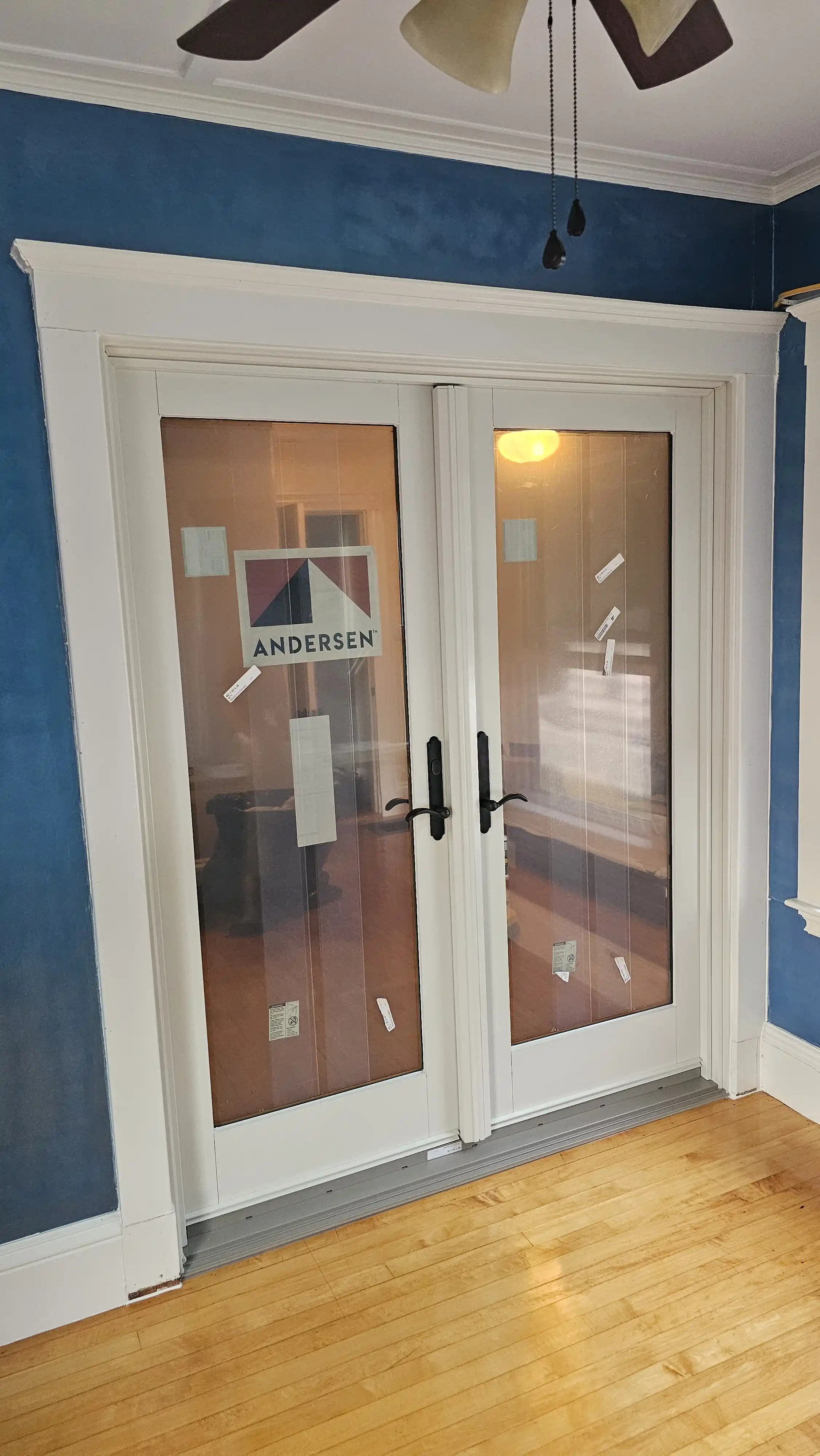White double patio doors with full glass panels and black handles