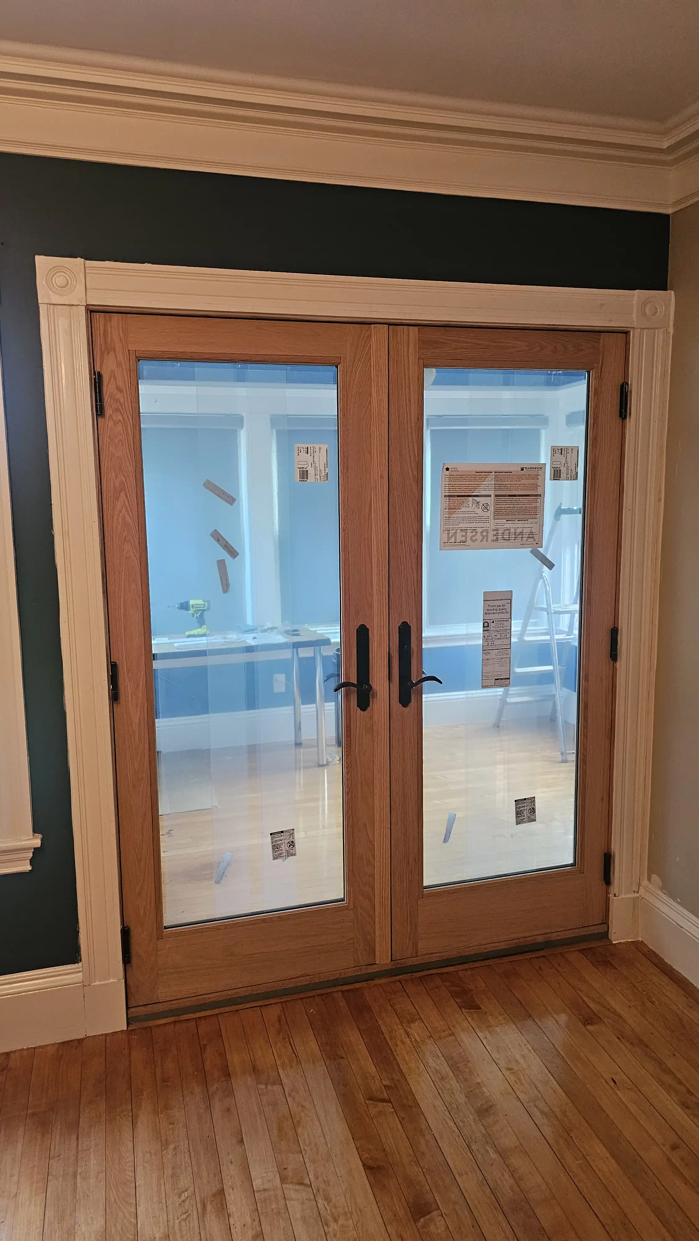 Oak-finish double patio doors with clear glass panels and black handles