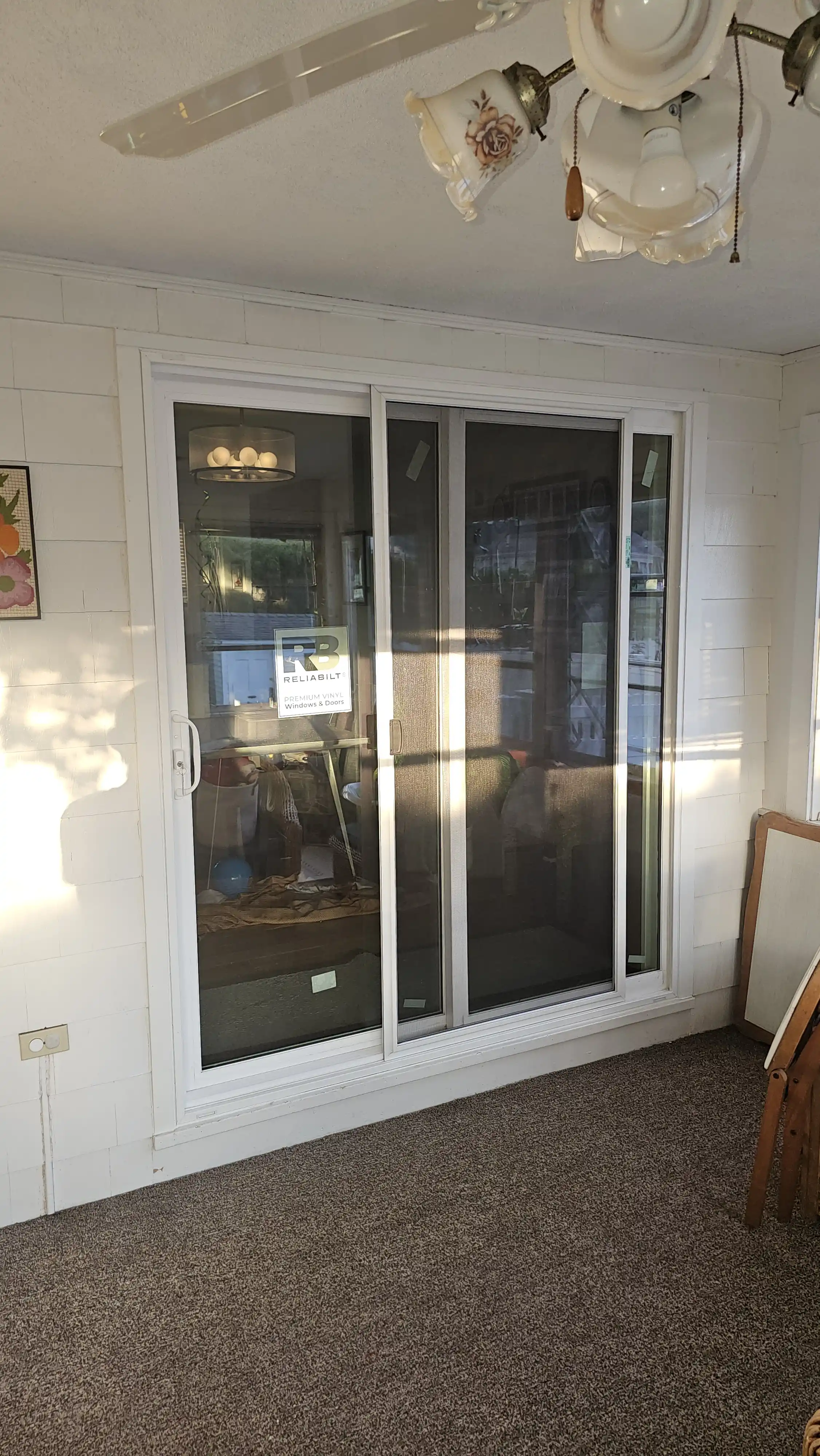 White vinyl patio sliding door with three glass panels and integrated screen