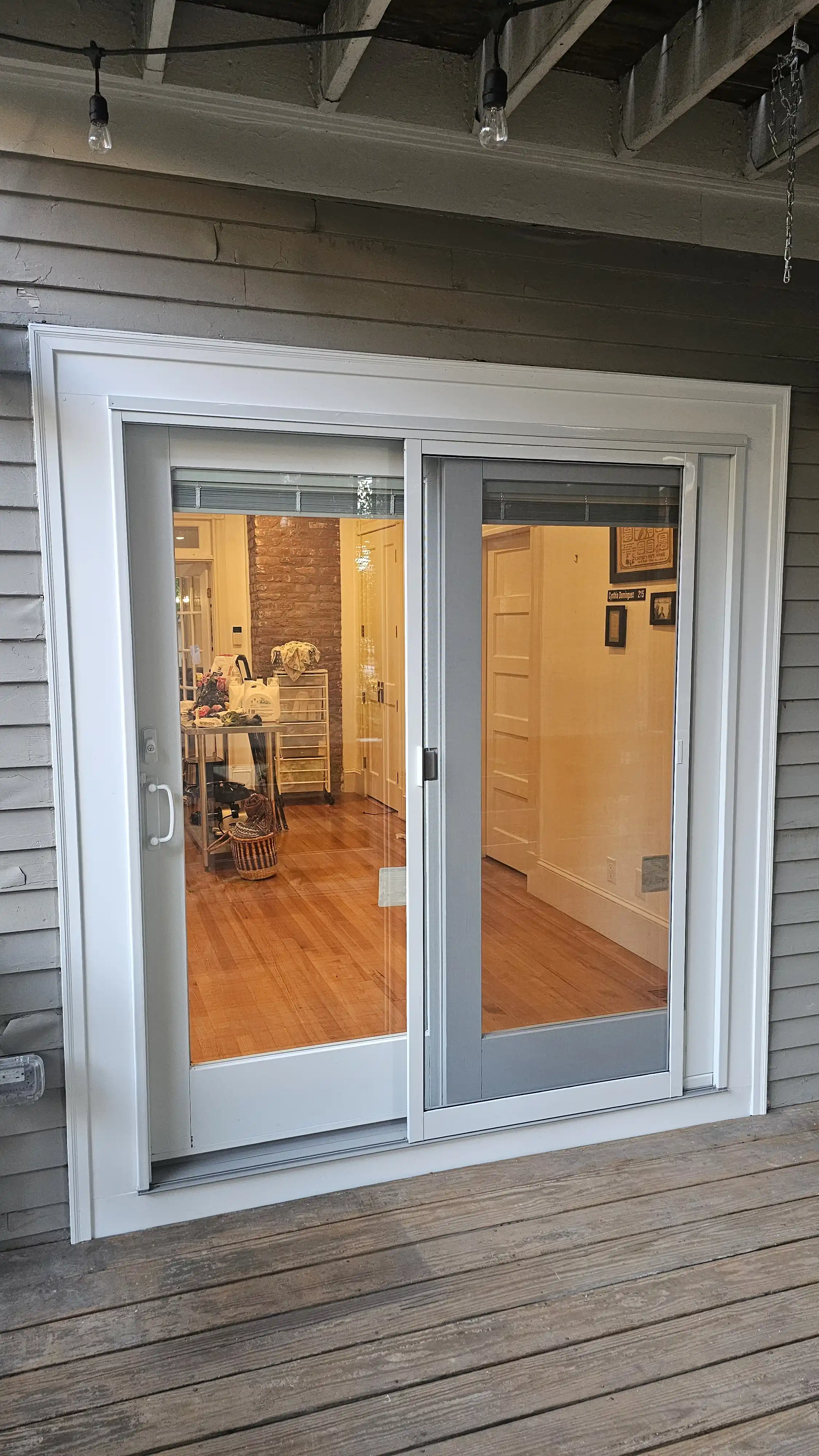 Modern sliding patio door with white frame and built-in blinds