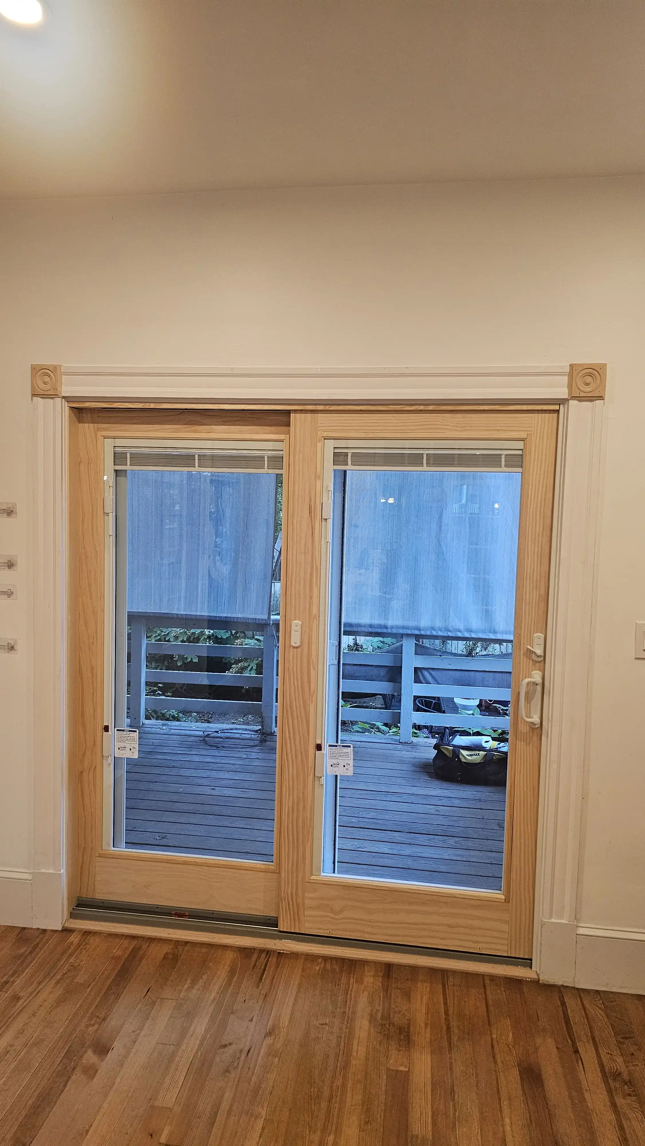 Dual-panel sliding patio doors with natural wood frame and clear glass