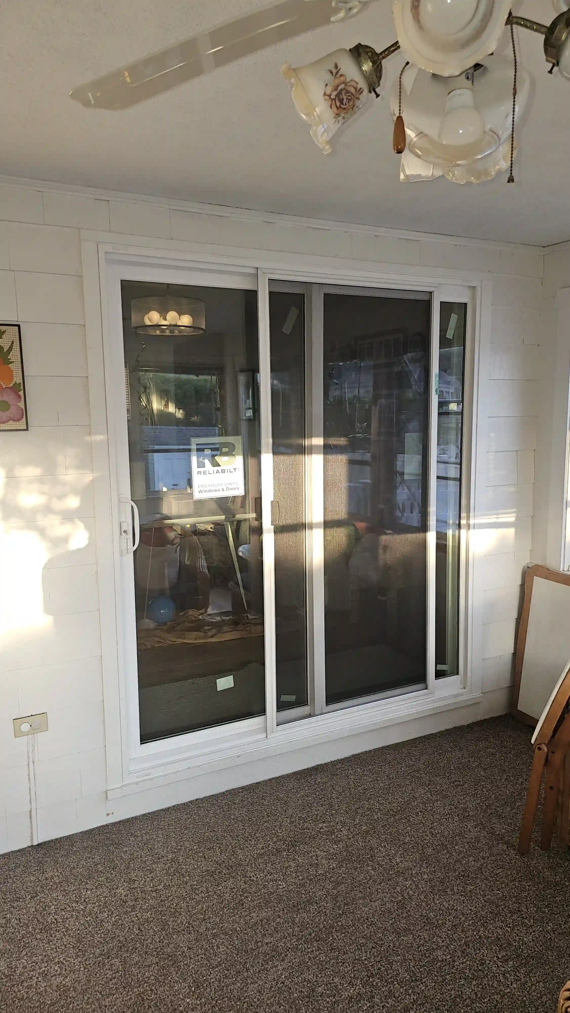 White vinyl patio sliding door with three glass panels and integrated screen