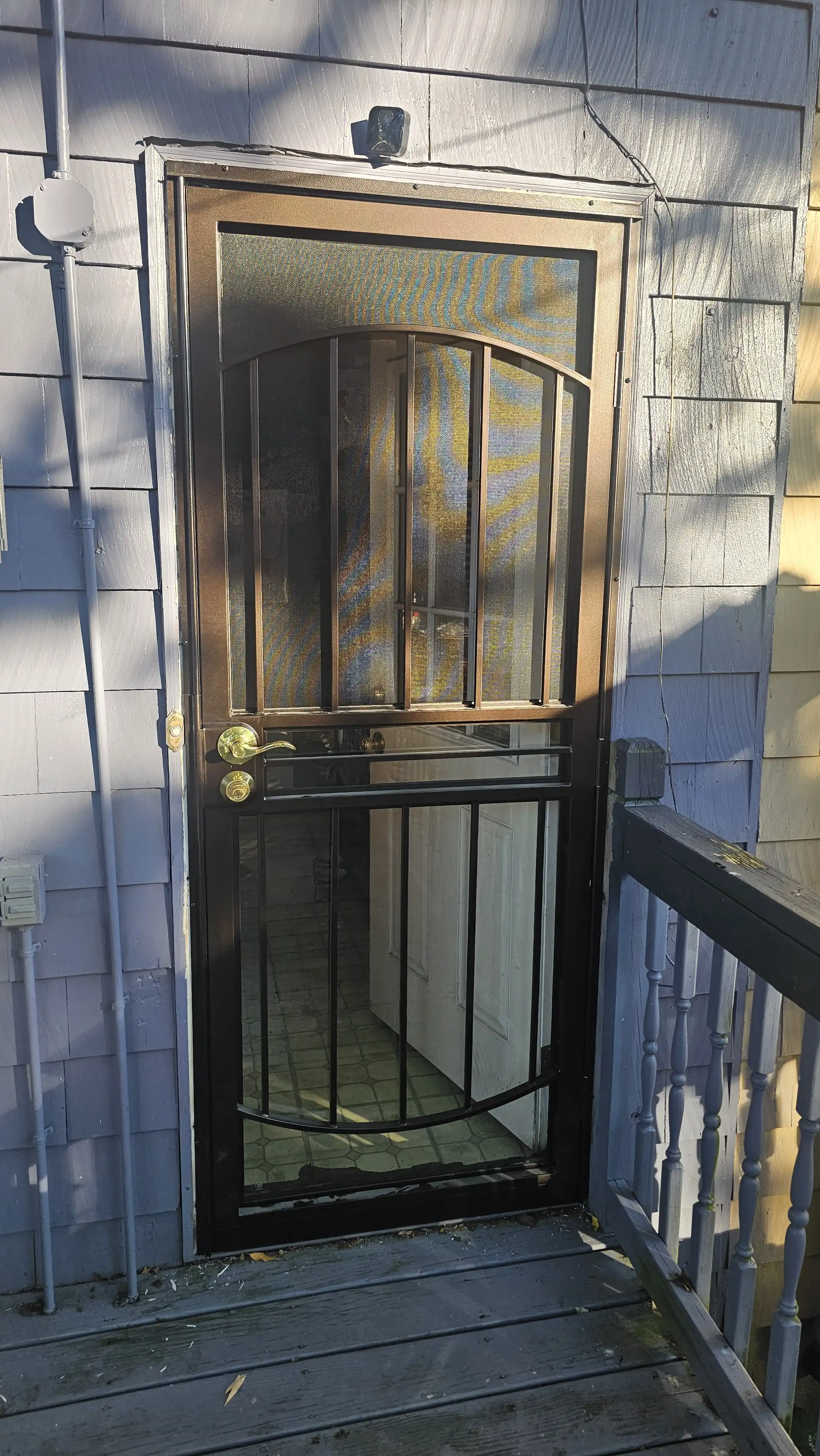 Heavy-duty storm door with metal bars and fine mesh panel