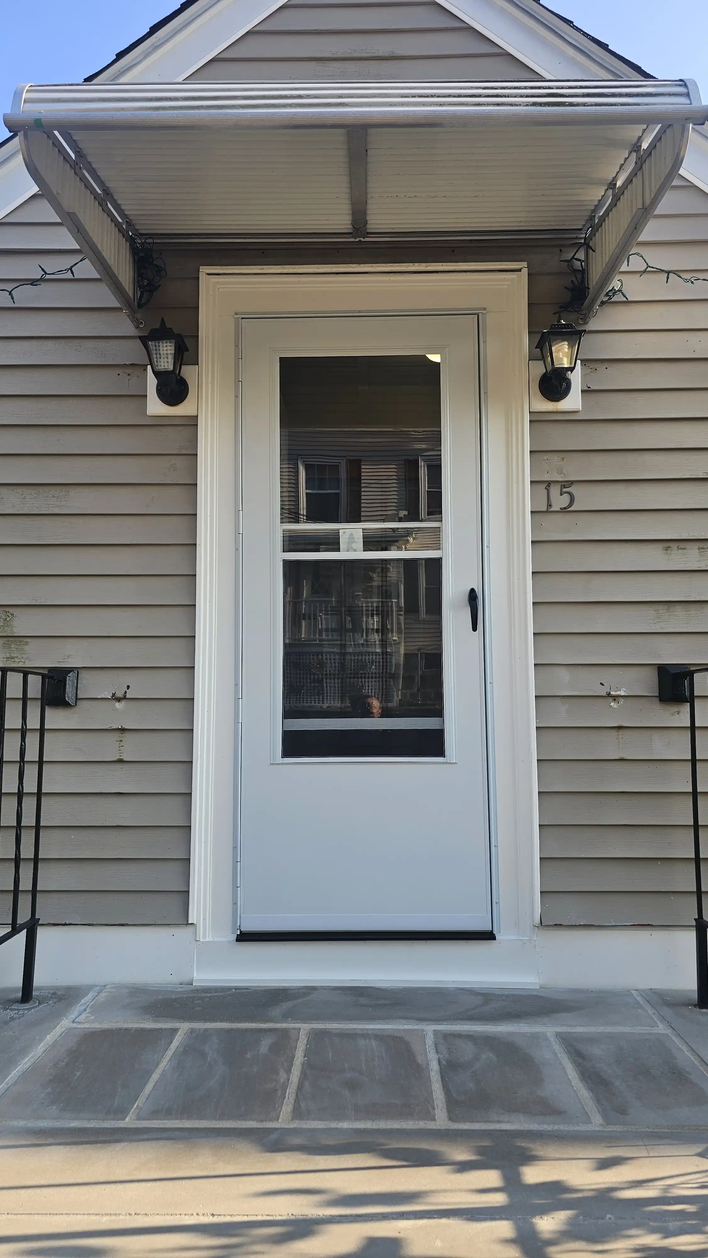 White storm door with a full glass panel and black handle.