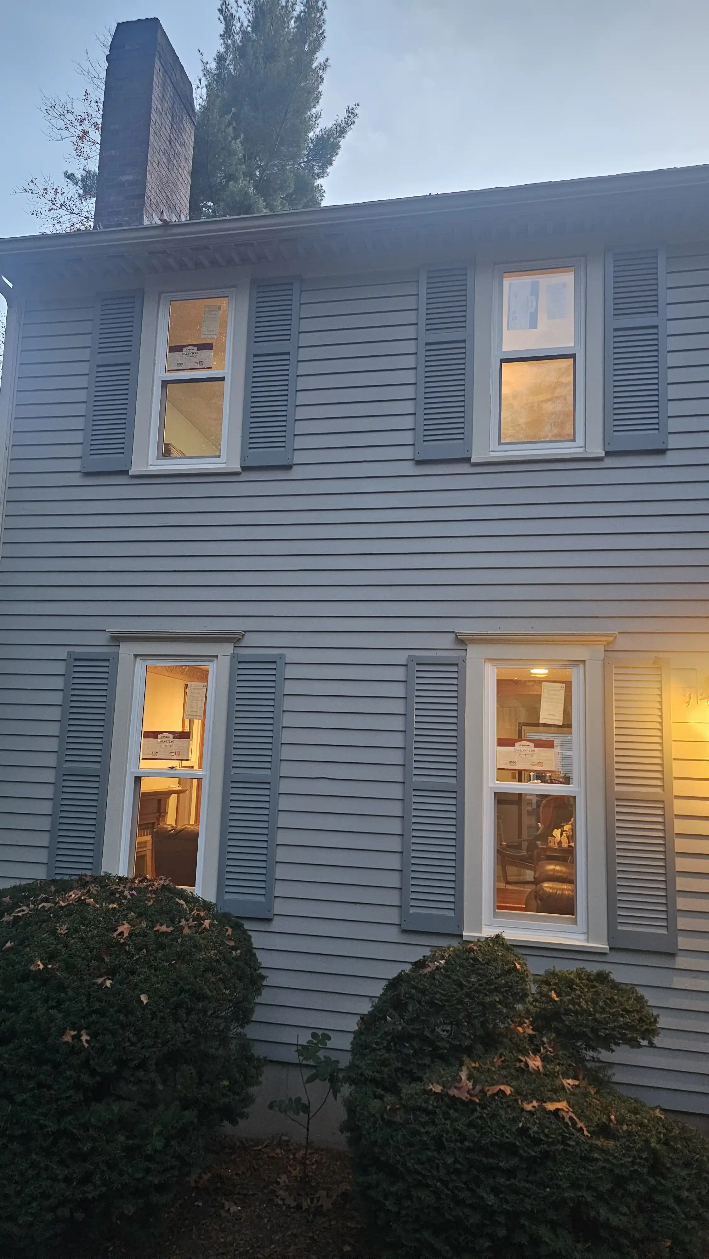 Arched top double-hung window with white trim and manufacturer stickers on the glass.